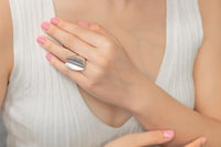 A close up of a model wearing a silver ring with the large gap in the middle