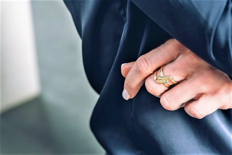A close up of a hand wearing a gold hashtag shaped ring