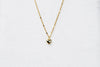 A gold chain necklace with a small heart penant on a white background.