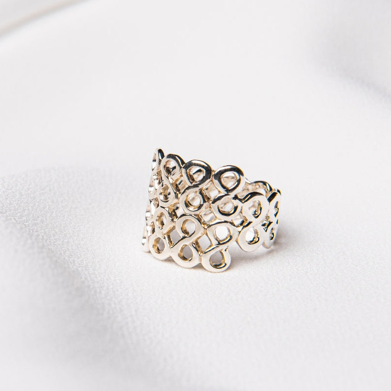 A honeycomb design silver ring on a white background