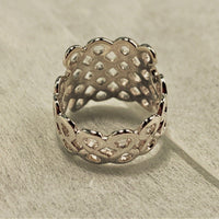 A honeycomb shaped ring on a white fabric background
