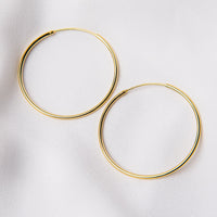 Two hoop earrings made of sterling silver with gold vermeil coating, displayed on a white background.