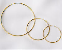 Three hoop earrings made of sterling silver with gold vermeil, displayed on a white background.
