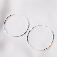 Two hoop earrings made of sterling silver, displayed on a white background.