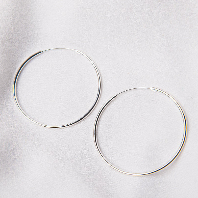 Two hoop earrings made of sterling silver, displayed on a white background.