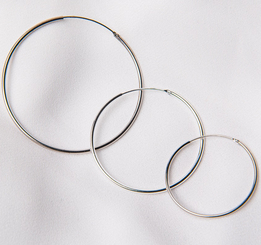 Three hoop earrings made of sterling silver, displayed on a white background.