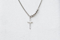 A silver necklace with a small cross pendant centered on a white background.