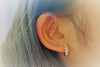 A women wearing a leaf huggies with cubic zirconia stone.