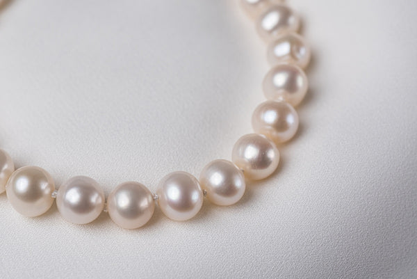 A magnificent white freshwater pearl displayed on a white surface