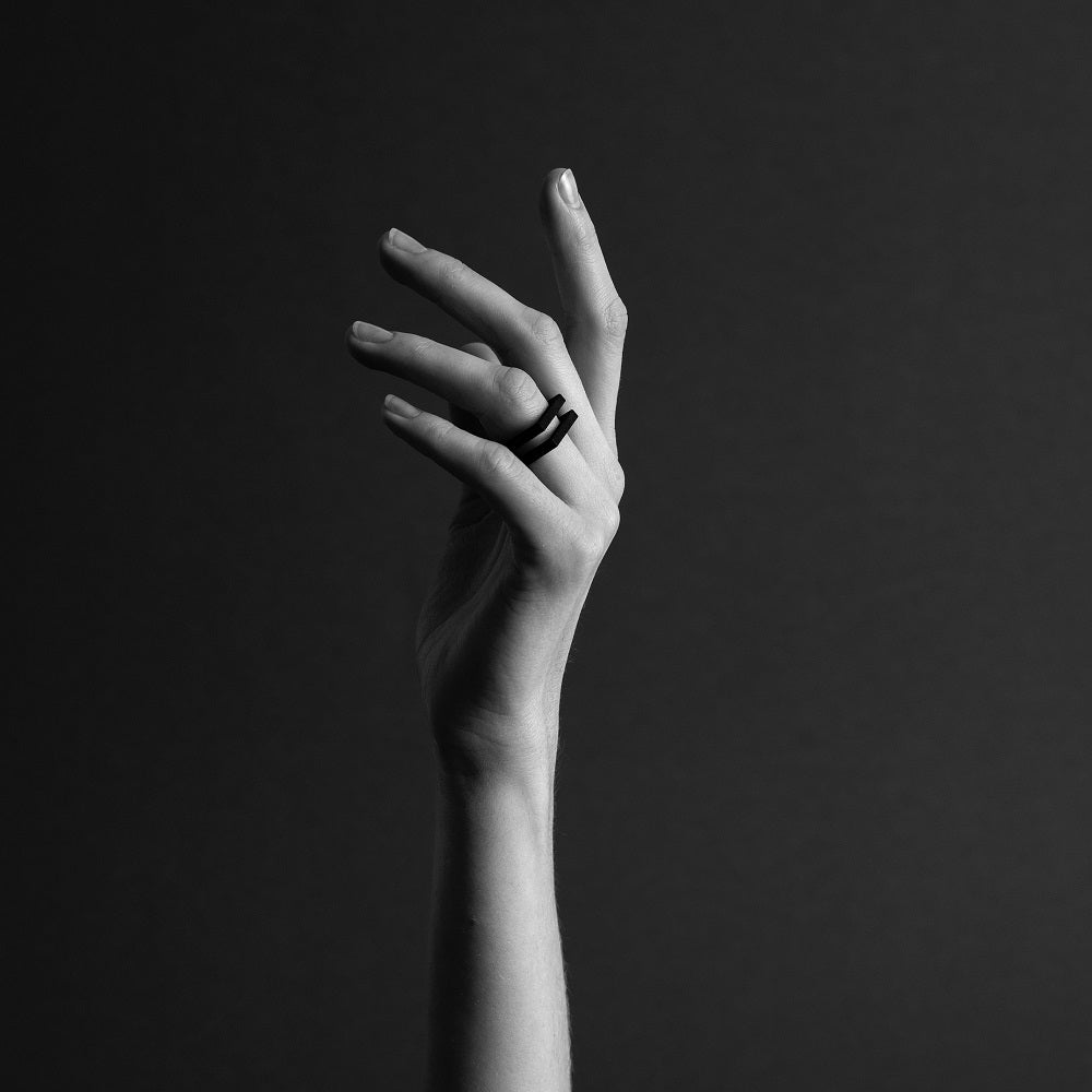 Close up of a hand wearing a black 3d printed ring