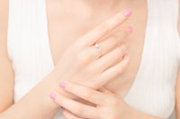 Close up of a womans hand wearing a silver ring featuring a pearl and cubic zirconias