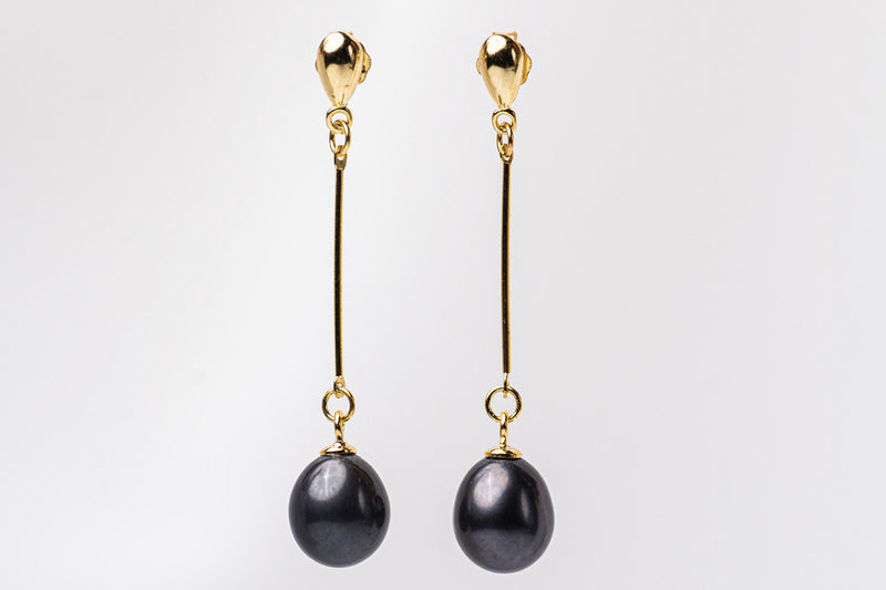 A pair of black pearl earrings with gold dangle components and butterfly backs, displayed against a white background.