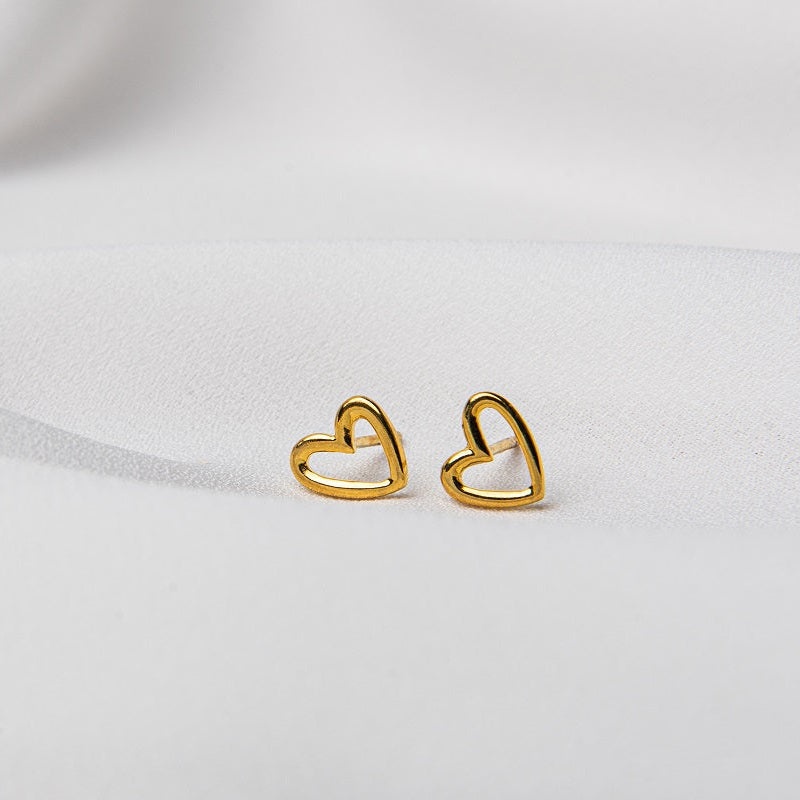 A pair of heart-shaped stud earrings made of sterling silver with gold vermeil coating, displayed on a white background.