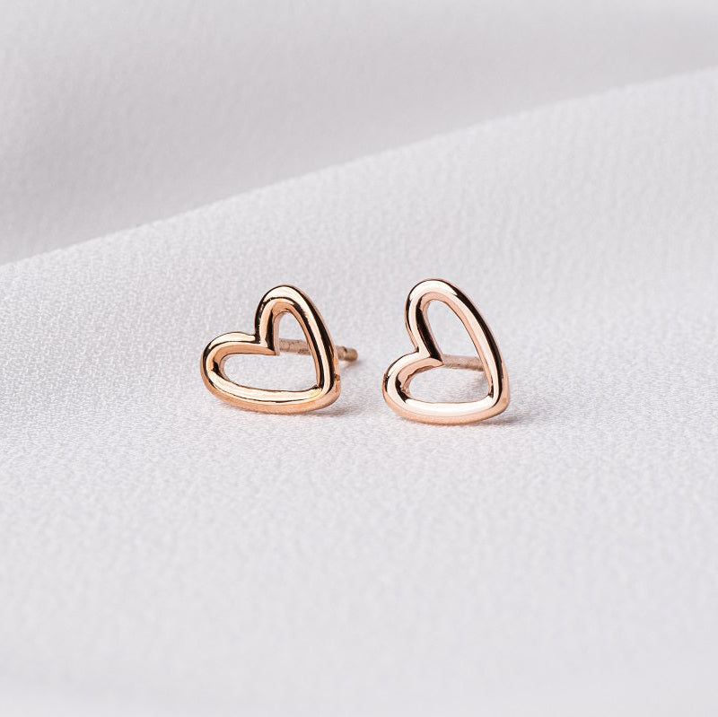 A pair of heart-shaped stud earrings made of sterling silver with rose gold vermeil coating, displayed on a white background.
