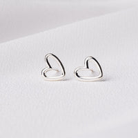 A pair of heart-shaped stud earrings made of sterling silver displayed on a white background.