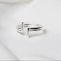 A silver ring placed on a white fabric background