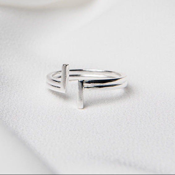A silver ring placed on a white fabric background