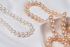 A freshwater white and champagne pearl necklace display on a white background 