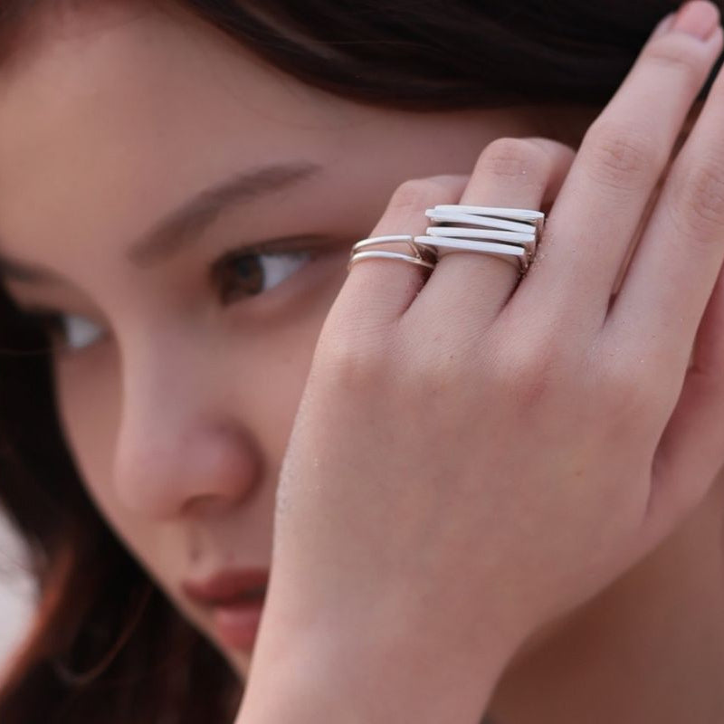 A close up of a woman wearing a banded silver ring.