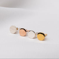 Four round studs on a white cloth background