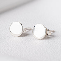 Pair of sterling silver round studs on a white cloth background