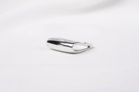 A polished silver ring with a unique design, featuring a loop-shaped top on a white background.