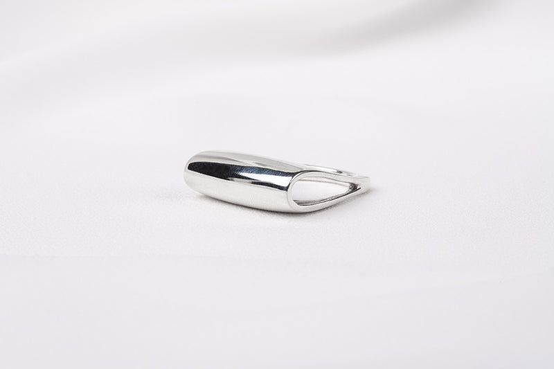 A polished silver ring with a unique design, featuring a loop-shaped top on a white background.
