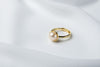 A gold pearl ring on a white cloth background