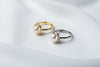 A gold pearl ring and a silver pearl ring on a white cloth background