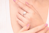 Close up of a womans hand wearing a silver and pearl ring