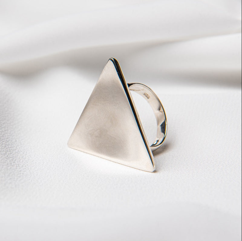 A silver ring with a triangular shape on a white background.