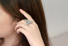 Close up of a model wearing a silver triangle shaped ring