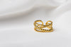 An adjustable gold vermeil ring with a twisted design, displayed on a white fabric surface.