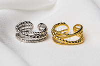 A silver and a gold adjustable ring on a white cloth