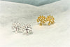Silver and gold tree shaped stud earrings on a white background