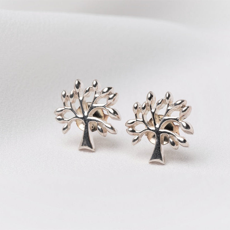 Silver tree shaped stud earrings on a white background