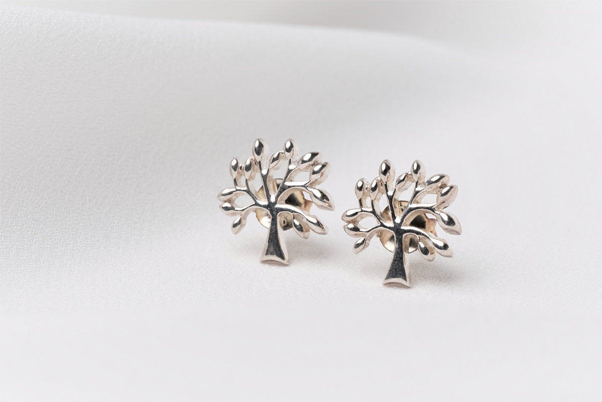Silver tree shaped stud earrings on a white background