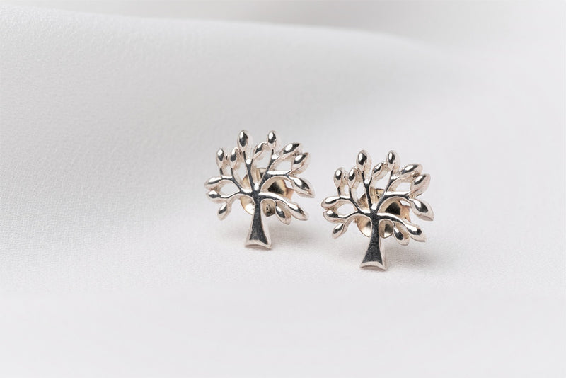 Silver tree shaped stud earrings on a white background