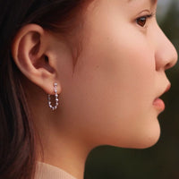 a woman wearing you and me sterling silver earrings 